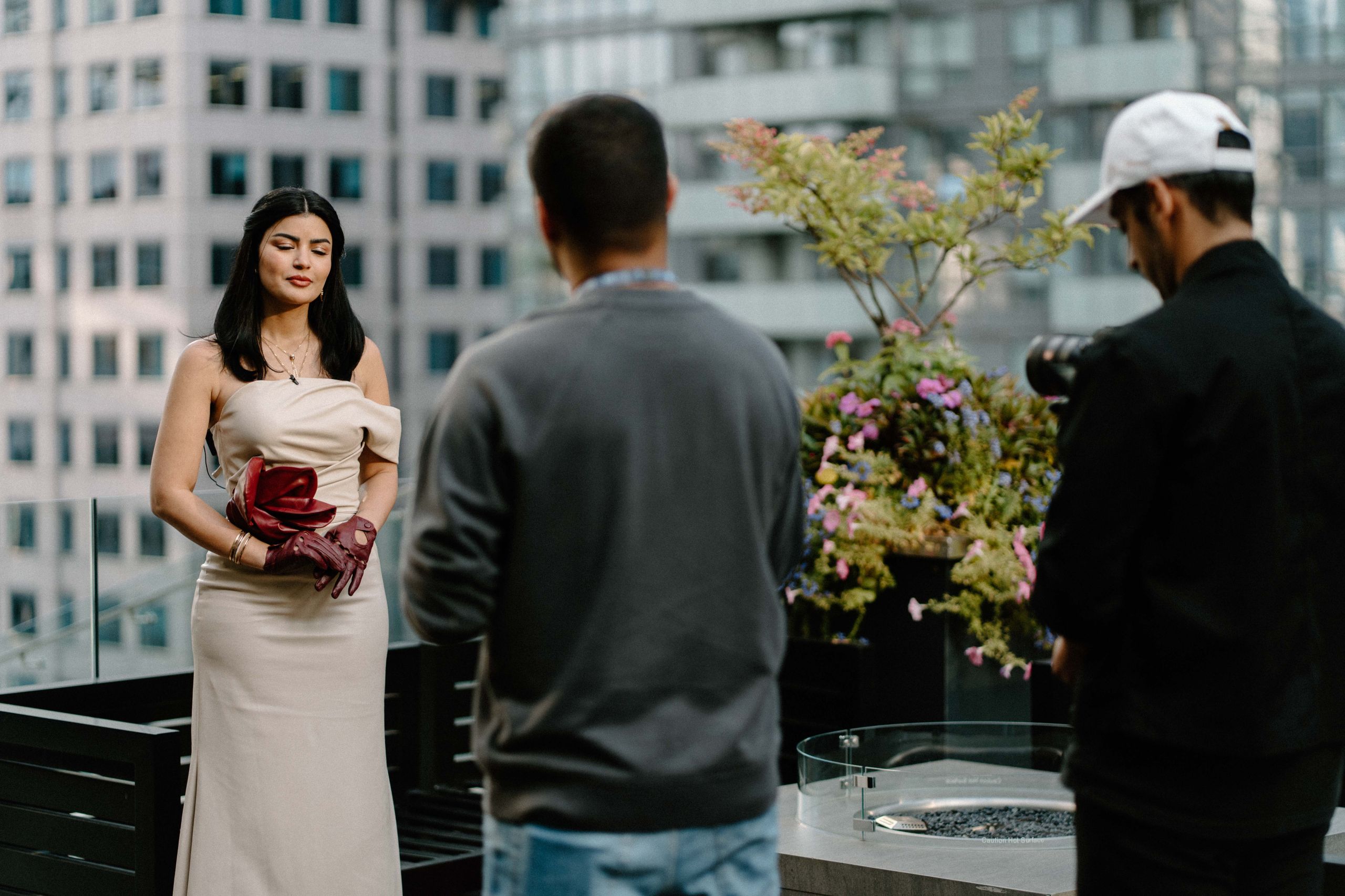 Professional brand photography on Toronto rooftop with model in elegant nude dress and dark red leather gloves posing during a fashion shoot by Origin Films