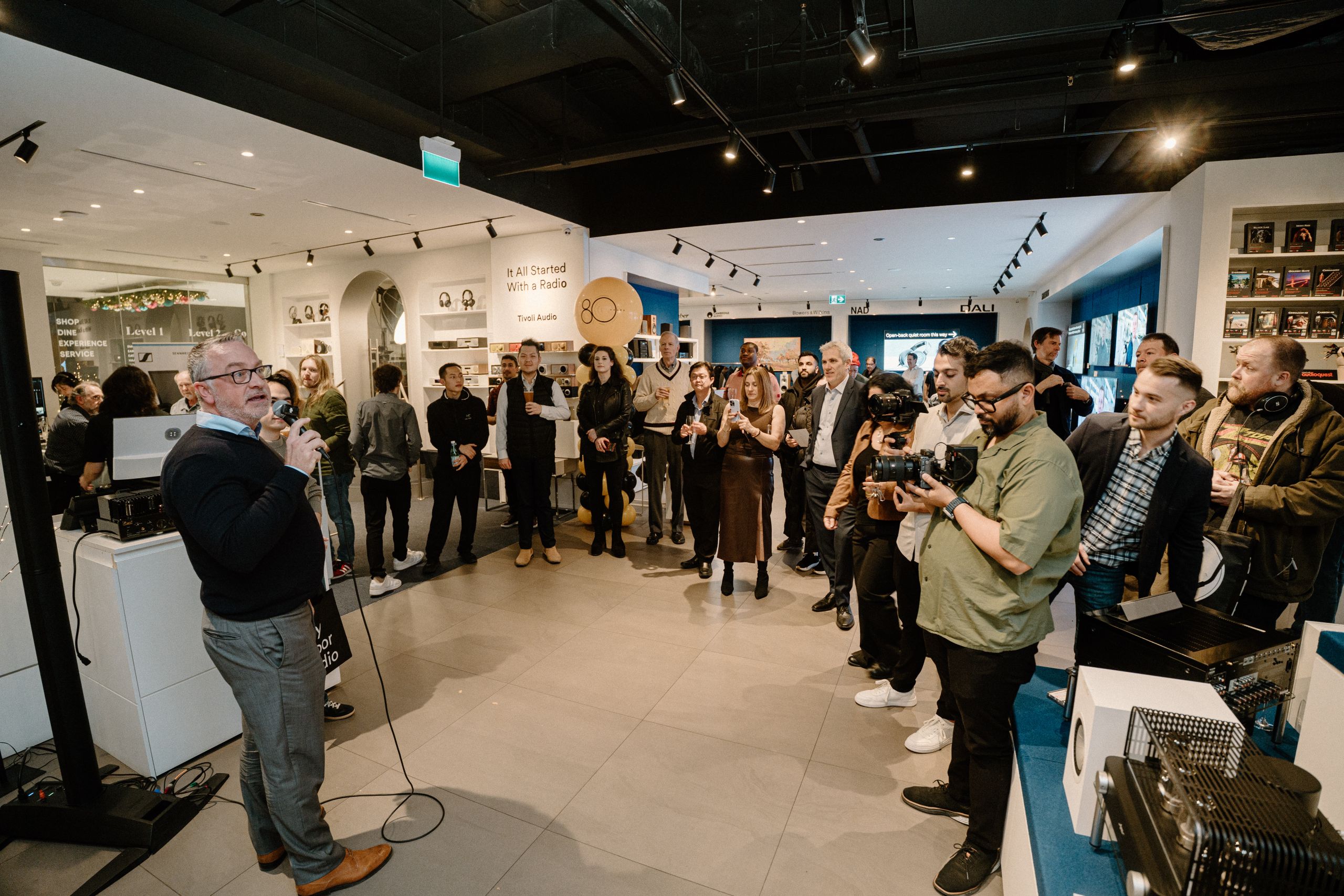 Tivoli Audio 30th anniversary product launch event photography showing speaker at microphone with guests at a Toronto audio store event captured by Origin Films professional event photography