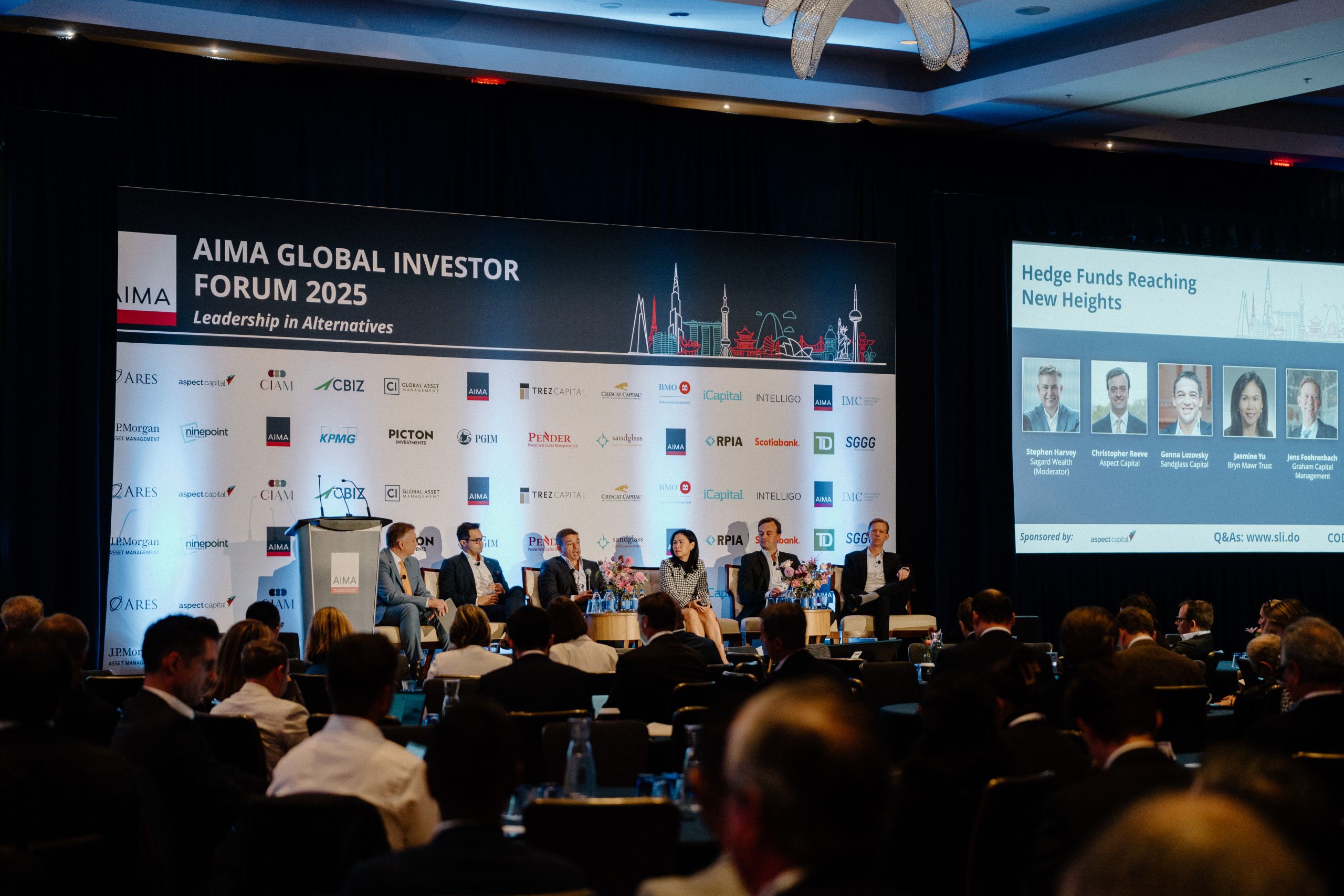 AIMA Global Investor Forum 2025 Hedge Funds Reaching New Heights panel with speakers on stage and full auditorium of finance professionals by Origin Films Toronto event photography