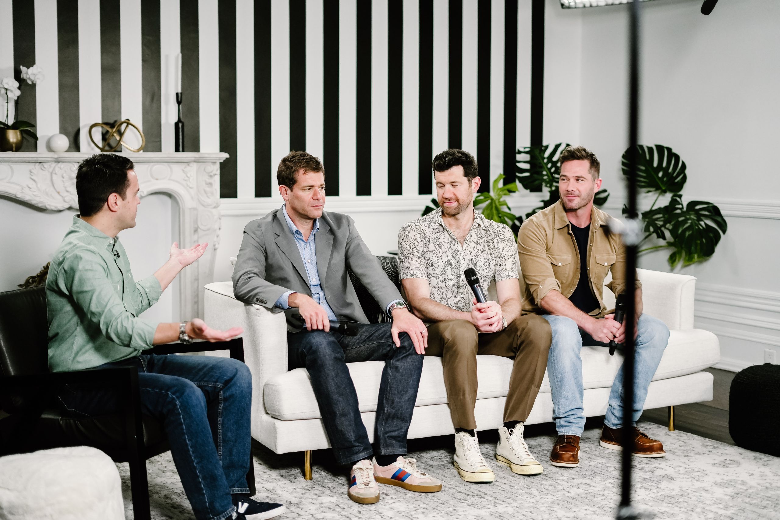 Four men in panel discussion interview seated on white sofas in a professional studio setting for corporate interview videography by Origin Films Toronto